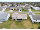 Backyard scene with a screen enclosed porch, featuring a lush green lawn, and neighborhood views at 606 San Maria Street, Lady Lake, FL 32159