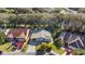 Aerial view of a light blue home with a well-manicured lawn and mature trees in a quiet neighborhood at 705 Cortez Ave, The Villages, FL 32159