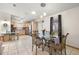 Open-concept dining area featuring a glass table set, stylish lighting, and kitchen view at 705 Cortez Ave, The Villages, FL 32159