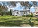 Charming one-story home with light blue siding, well-maintained lawn, and lush landscaping at 705 Cortez Ave, The Villages, FL 32159