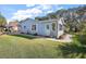 Charming single-story home with light blue siding, green lawn, and well-maintained landscaping at 705 Cortez Ave, The Villages, FL 32159