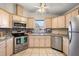 Modern kitchen with stainless steel appliances, tiled backsplash, and ample cabinet space at 705 Cortez Ave, The Villages, FL 32159