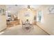 Light-filled dining area with a round table, four chairs, neutral carpet, and view to breakfast bar at 736 Heathrow Ave, The Villages, FL 32159