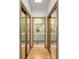Hallway with mirrored closets leading to a bright bathroom with a double sink vanity at 736 Heathrow Ave, The Villages, FL 32159