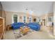 Cozy living room features a ceiling fan, two sofas, large windows, and a neutral color palette at 736 Heathrow Ave, The Villages, FL 32159
