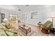 Inviting living room with tiled floors, floral sofa, and ample natural light creates a welcoming atmosphere at 736 Heathrow Ave, The Villages, FL 32159
