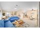 Cozy living and dining area featuring comfortable blue seating, a ceiling fan, and an open floor plan at 736 Heathrow Ave, The Villages, FL 32159