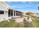 Exterior view of backyard patio and lanai, overlooking the lake at 736 Heathrow Ave, The Villages, FL 32159