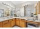 Bathroom boasts double sinks, wood cabinets, ample counter space, and well-lit vanity mirrors at 8294 Se 177Th Winterthur Loop, The Villages, FL 32162