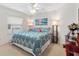 Cozy bedroom with a ceiling fan, a large window, and beach-themed art above the bed at 8294 Se 177Th Winterthur Loop, The Villages, FL 32162