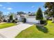 Well-manicured lawn and landscaping surround this single-story home with a two-car garage and concrete driveway at 8294 Se 177Th Winterthur Loop, The Villages, FL 32162