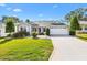 Charming single-story home featuring a well-maintained lawn, manicured shrubs, and a two-car garage with a concrete driveway at 8294 Se 177Th Winterthur Loop, The Villages, FL 32162