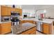 Bright kitchen featuring light wood cabinets, granite countertops, stainless steel appliances, and serving bar at 8294 Se 177Th Winterthur Loop, The Villages, FL 32162
