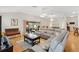 Bright living room with wood floors, sliding glass doors to a screened patio, and comfortable sectional sofa at 8294 Se 177Th Winterthur Loop, The Villages, FL 32162