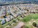 Stunning aerial shot of a golf course community with homes, a pond, and lush green fairways at 9052 Se 130Th Loop, Summerfield, FL 34491