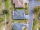 Aerial view of a residential property, showcasing the roof, driveway, landscaping, and surrounding neighborhood at 9052 Se 130Th Loop, Summerfield, FL 34491