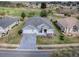 Aerial view of a home featuring lush landscaping, a spacious driveway, and a well-manicured lawn at 9052 Se 130Th Loop, Summerfield, FL 34491