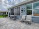 Backyard patio area with outdoor seating, featuring a decorative wall and partial views of the neighborhood at 9052 Se 130Th Loop, Summerfield, FL 34491