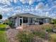 Well-maintained backyard featuring a paver patio, seating area, and views of the surrounding landscape at 9052 Se 130Th Loop, Summerfield, FL 34491