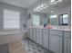 Bright bathroom with a large mirror, dual sinks, and a soaking tub under a window for natural light at 9052 Se 130Th Loop, Summerfield, FL 34491