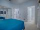 This carpeted bedroom features ensuite bathroom access, mirrored closet, and wood flooring outside bathroom door at 9052 Se 130Th Loop, Summerfield, FL 34491