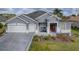 Charming one-story home with a well-manicured lawn, red front door, and a two car garage at 9052 Se 130Th Loop, Summerfield, FL 34491