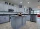 Charming kitchen featuring light gray cabinets, stainless steel appliances, and a center island at 9052 Se 130Th Loop, Summerfield, FL 34491