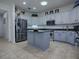 Spacious kitchen with stainless steel appliances, gray cabinets, and an inviting center island at 9052 Se 130Th Loop, Summerfield, FL 34491