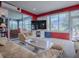 Bright living room featuring comfortable seating, a large TV, and sliding glass doors with scenic views at 9052 Se 130Th Loop, Summerfield, FL 34491