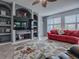 Inviting living room featuring a large TV, custom shelving, and comfortable seating at 9052 Se 130Th Loop, Summerfield, FL 34491