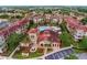 Aerial view of a condo community with multiple buildings, a pool area, lush gardens, and ample parking at 907 Charo Pkwy # 915, Davenport, FL 33897