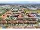 Aerial view of community featuring resort-style pool, lush landscaping and beautiful red tile roofs at 907 Charo Pkwy # 915, Davenport, FL 33897