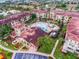 Overhead view of a condo community featuring multiple buildings, swimming pool, parking, and colorful landscaping at 907 Charo Pkwy # 915, Davenport, FL 33897