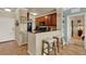 A compact kitchen with wood cabinets, a breakfast bar with seating, and views to other rooms in the condo at 907 Charo Pkwy # 915, Davenport, FL 33897