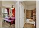 This primary bedroom features a ceiling fan, bench, and large window for natural light with a full bathroom at 907 Charo Pkwy # 915, Davenport, FL 33897