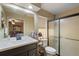 Modern bathroom with a large mirror, vanity, and a glass-enclosed shower, and a fan at 909 Palm Forest Ln, Minneola, FL 34715