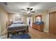 Comfortable bedroom featuring hardwood furniture, a bed with a striped comforter, and natural light at 909 Palm Forest Ln, Minneola, FL 34715