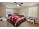 Bright bedroom featuring a colorful bed, a ceiling fan, and two windows letting in natural light at 909 Palm Forest Ln, Minneola, FL 34715