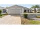 A home featuring a brick paved driveway leading to a one-car garage at 9312 Se 172Nd Wayside Pl, The Villages, FL 32162