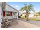 Relaxing front porch featuring brick pavers, retractable awning, and two chairs at 9312 Se 172Nd Wayside Pl, The Villages, FL 32162