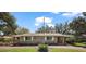 Charming brick home featuring white shutters and a well-manicured lawn on a sunny day at 9810 Jackson Rd, Leesburg, FL 34788