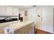 Functional kitchen featuring white cabinets, black countertops, and hardwood floors at 9810 Jackson Rd, Leesburg, FL 34788