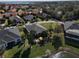 Aerial view of neighborhood homes featuring well-maintained landscaping and lake views in a sunny setting at 10173 Julia Isles Ave, Oxford, FL 34484