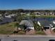 Aerial view of homes near a lake with lush landscaping and mature trees in a residential neighborhood at 10173 Julia Isles Ave, Oxford, FL 34484