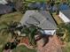 Overhead view of single Gathering home situated on a large corner lot with a pond nearby at 10173 Julia Isles Ave, Oxford, FL 34484