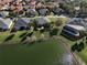 Aerial view of lakeside homes featuring manicured lawns, mature trees, and beautiful landscaping at 10173 Julia Isles Ave, Oxford, FL 34484