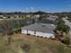 Aerial view showcases home by lake; features well-manicured lawn, beautiful landscaping and mature trees at 10173 Julia Isles Ave, Oxford, FL 34484