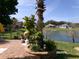 Brick patio with landscaping and lake view at 10173 Julia Isles Ave, Oxford, FL 34484