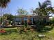 Spacious backyard with brick patio, outdoor furniture, and lush landscaping at 10173 Julia Isles Ave, Oxford, FL 34484