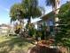 Landscaped backyard featuring a well-manicured lawn, trees, shrubs, and a brick border along the house at 10173 Julia Isles Ave, Oxford, FL 34484